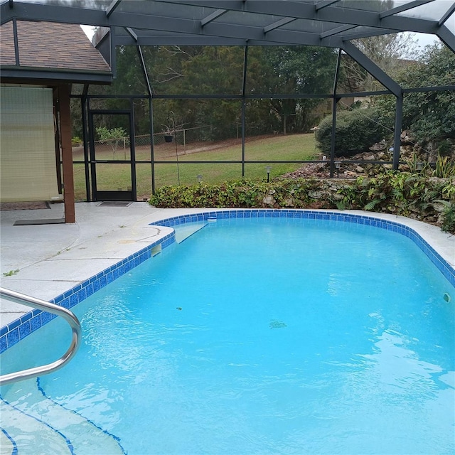 pool with glass enclosure and a patio