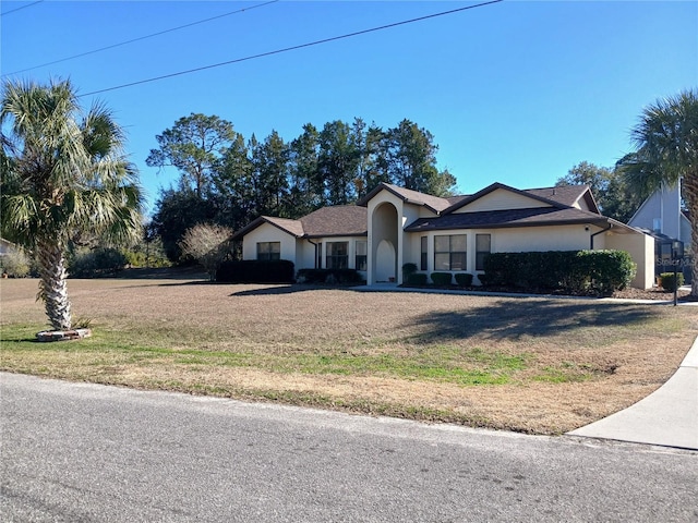 ranch-style house with stucco siding and a front yard