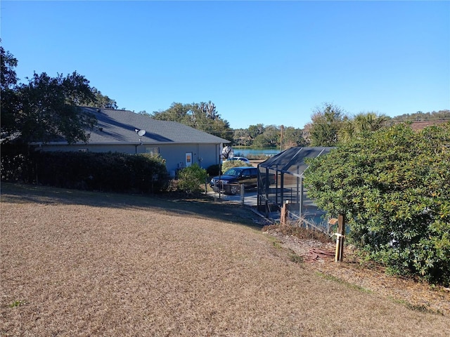 view of yard featuring a lanai and a water view