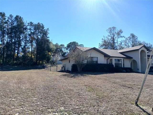 view of side of home featuring fence and stucco siding