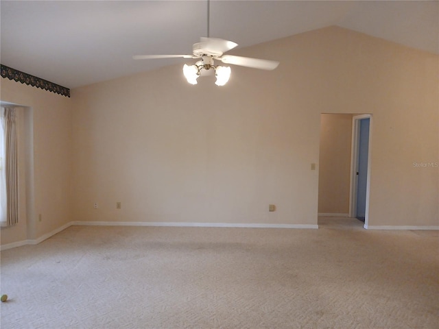 empty room with light carpet, lofted ceiling, a ceiling fan, and baseboards