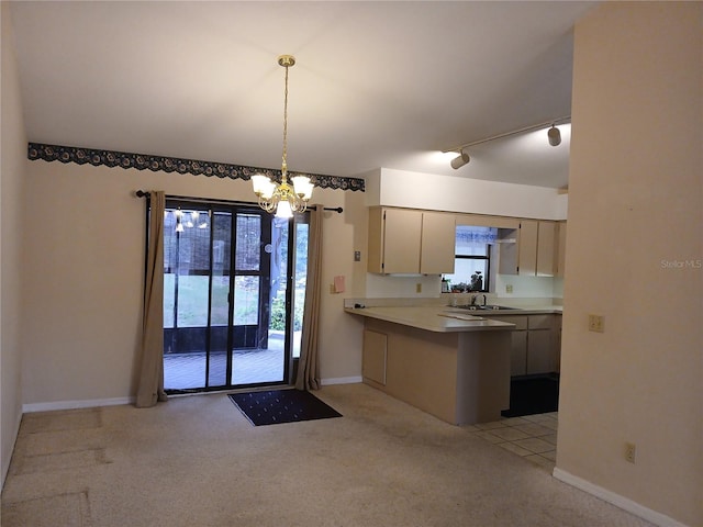 kitchen featuring cream cabinetry, light countertops, hanging light fixtures, light carpet, and a sink