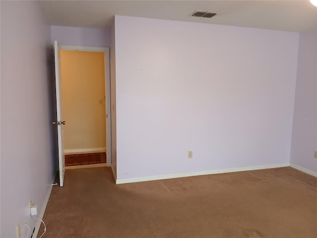 unfurnished room featuring carpet floors, visible vents, and baseboards