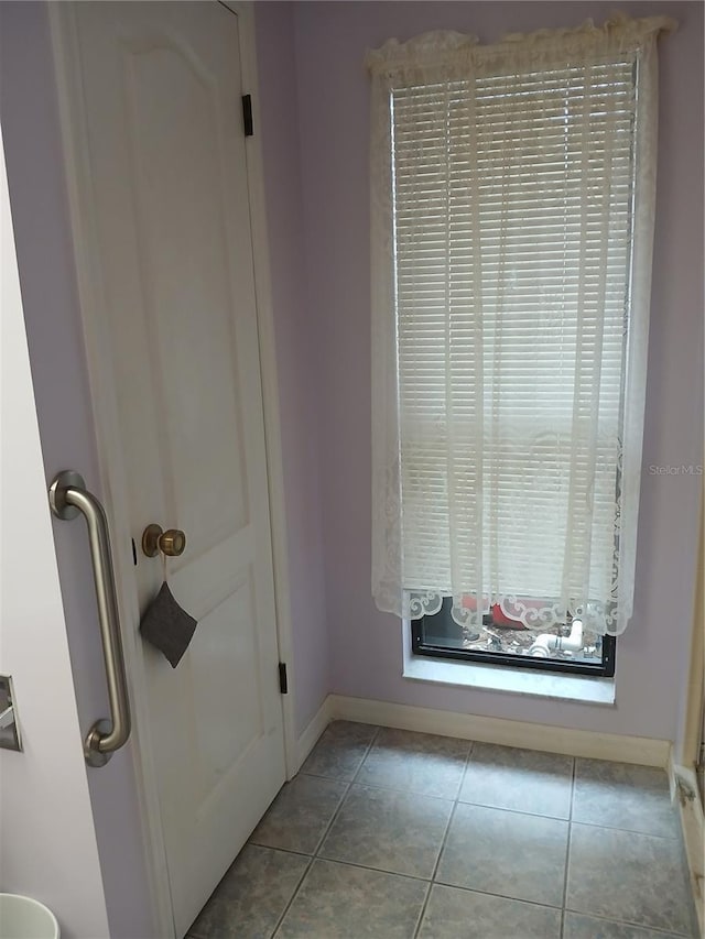 interior space featuring baseboards and light tile patterned flooring