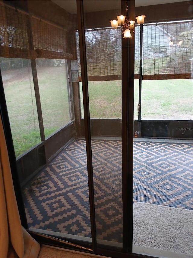 sunroom / solarium featuring a chandelier