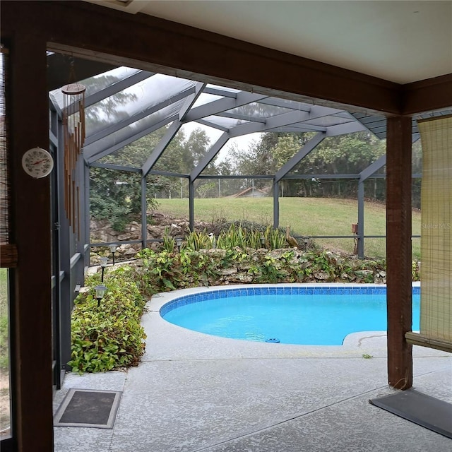 pool featuring glass enclosure and a patio area