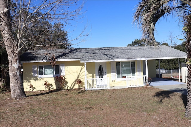 single story home featuring a front lawn, a carport, and a porch