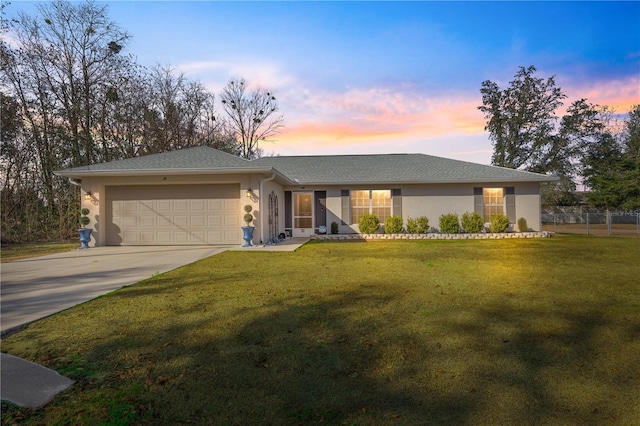 view of front of house featuring a garage and a lawn