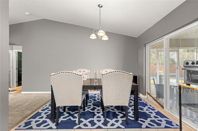 dining area featuring vaulted ceiling, tile patterned floors, and an inviting chandelier