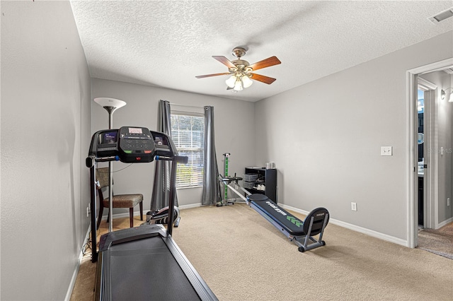 exercise room with a textured ceiling, ceiling fan, and carpet