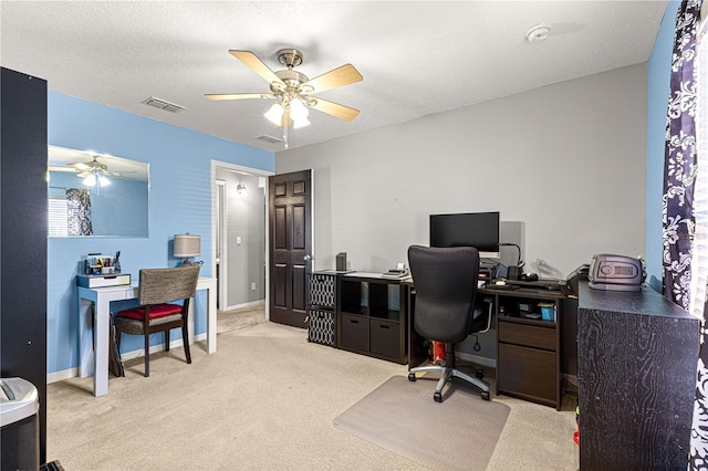 carpeted home office with a textured ceiling and ceiling fan