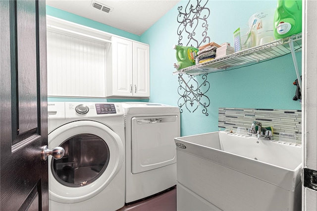 laundry room featuring cabinets, washer and dryer, and sink