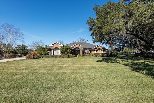 ranch-style home featuring a front yard