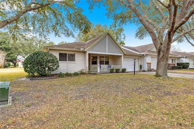 single story home featuring a garage, a front lawn, and a porch