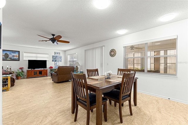 dining space with a textured ceiling and ceiling fan