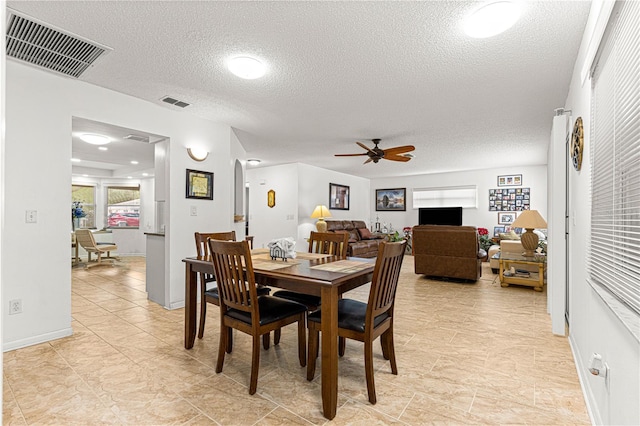 dining space with a textured ceiling and ceiling fan