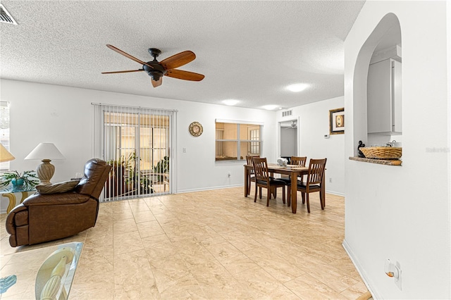 dining space featuring a textured ceiling and ceiling fan