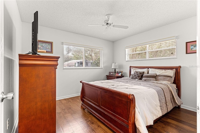 bedroom with a textured ceiling, dark wood-type flooring, and ceiling fan