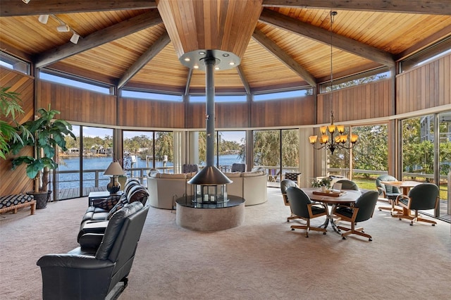 sunroom with a water view, vaulted ceiling with beams, wooden ceiling, and a chandelier