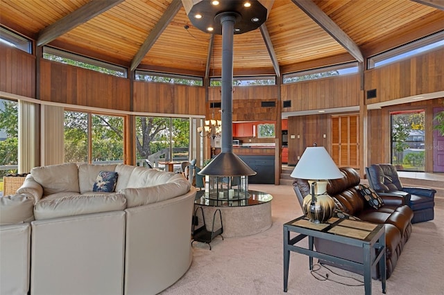 carpeted living room featuring wood ceiling, plenty of natural light, wooden walls, and a wood stove