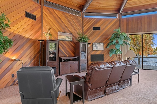 living room with carpet, wooden walls, and beam ceiling