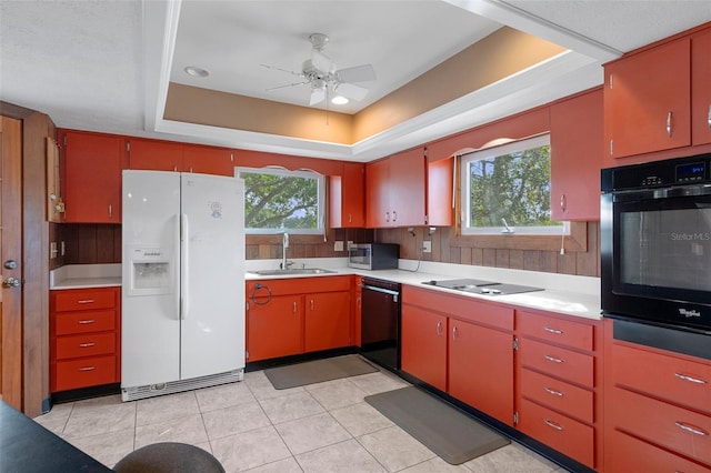 kitchen featuring a healthy amount of sunlight, a raised ceiling, sink, and black appliances