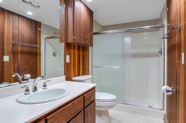 bathroom featuring tile patterned floors, toilet, a shower with shower door, and vanity