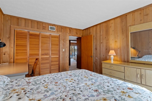 bedroom featuring a closet and wood walls