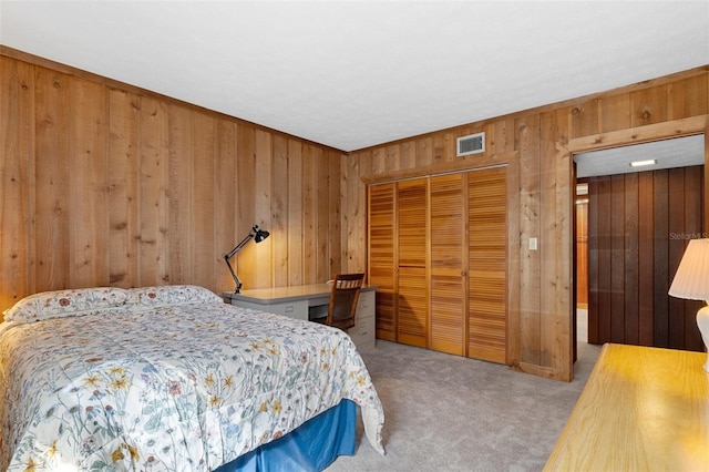 carpeted bedroom featuring elevator, wooden walls, and a closet