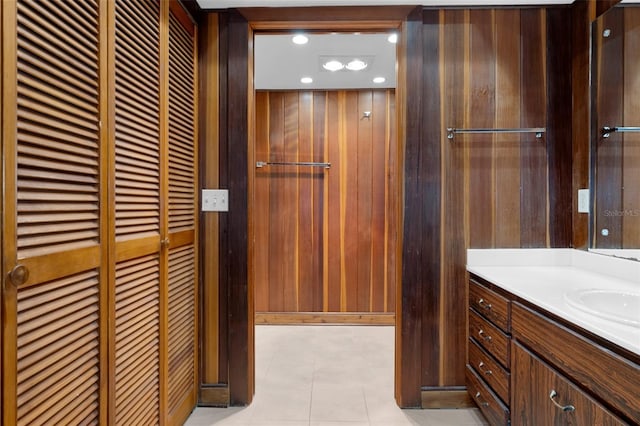 bathroom with vanity, wooden walls, and tile patterned floors