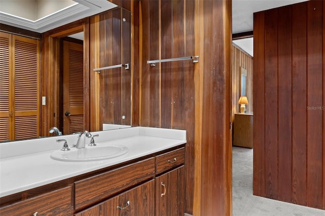 bathroom with vanity and wooden walls