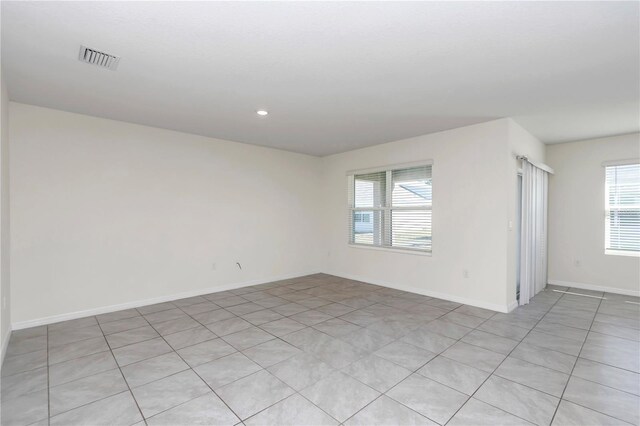 tiled spare room featuring plenty of natural light