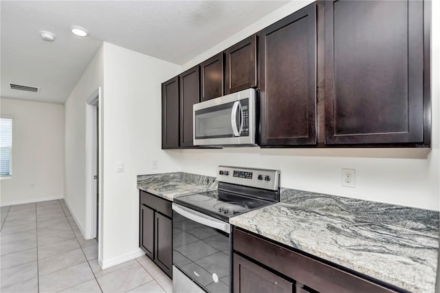 kitchen with light stone counters, dark brown cabinetry, appliances with stainless steel finishes, and light tile patterned flooring