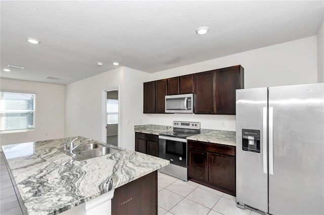 kitchen with a kitchen island with sink, sink, a wealth of natural light, and stainless steel appliances