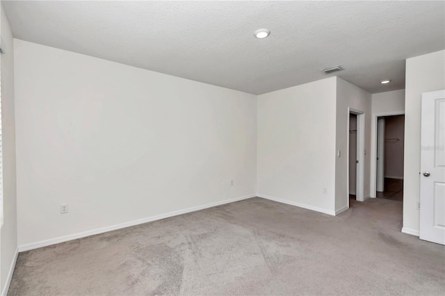 carpeted spare room with a textured ceiling