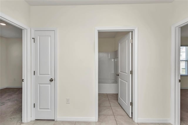 hall featuring light tile patterned floors