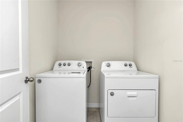 clothes washing area with tile patterned flooring and washing machine and clothes dryer