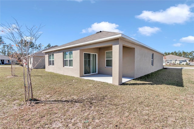 back of property with a yard and a patio area