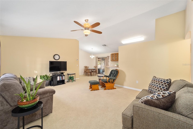 carpeted living room featuring ceiling fan with notable chandelier and vaulted ceiling