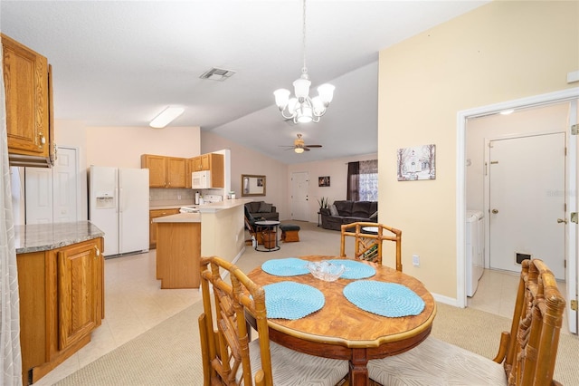 dining space with lofted ceiling, ceiling fan with notable chandelier, and separate washer and dryer