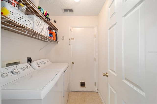 laundry room with washing machine and dryer and a textured ceiling