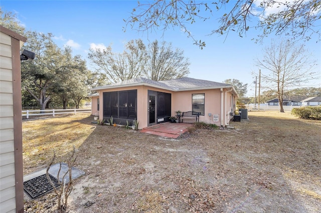 rear view of property featuring a sunroom and central air condition unit