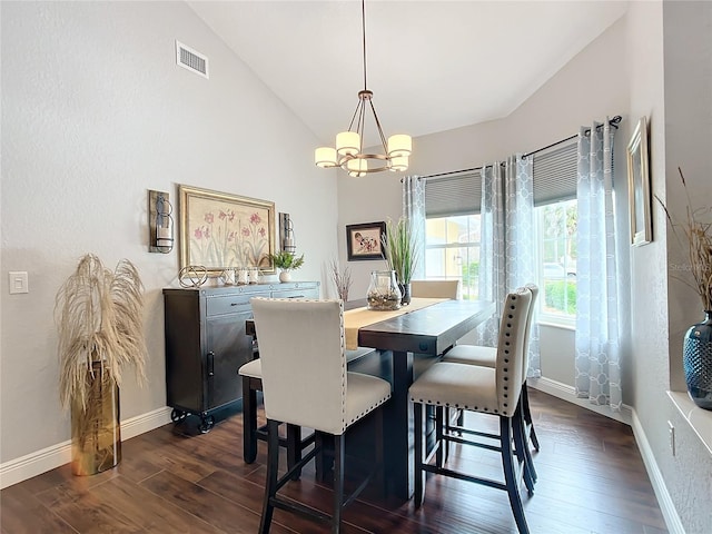 dining area with lofted ceiling, dark hardwood / wood-style floors, and a chandelier