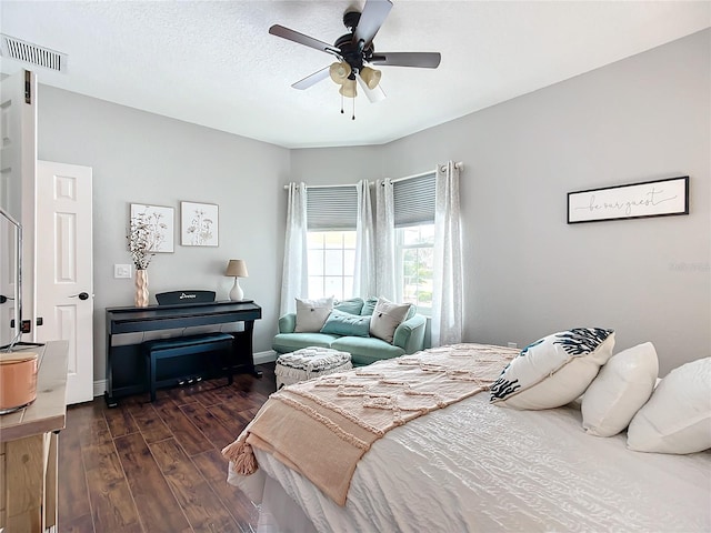 bedroom featuring ceiling fan, dark wood-type flooring, and a textured ceiling