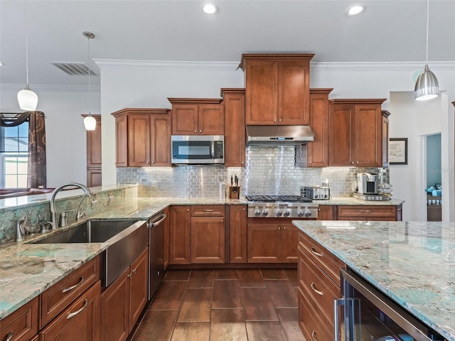 kitchen featuring sink, hanging light fixtures, stainless steel appliances, light stone countertops, and beverage cooler