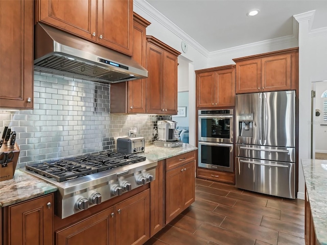 kitchen with stainless steel appliances, light stone countertops, decorative backsplash, and exhaust hood