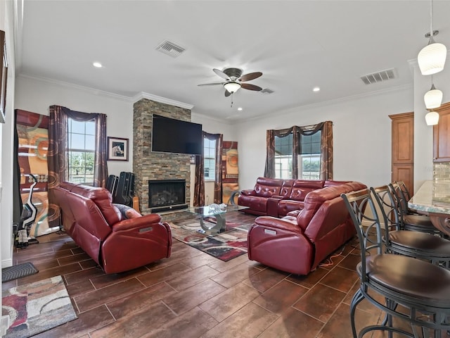 living room with a fireplace, ornamental molding, and ceiling fan