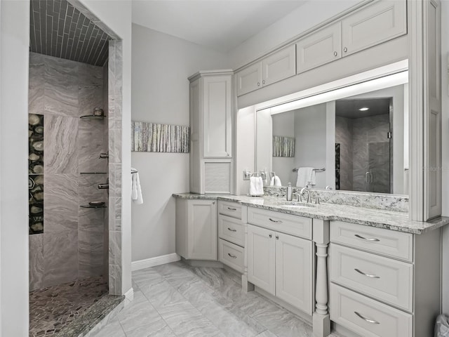 bathroom with vanity and a tile shower