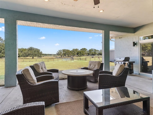 view of patio / terrace featuring an outdoor living space with a fire pit, area for grilling, a rural view, and ceiling fan