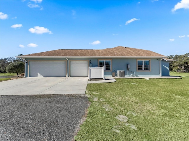 ranch-style home featuring a garage, central AC, and a front yard